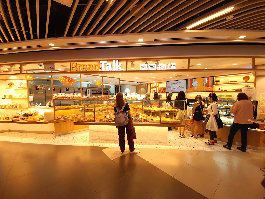 Customers browse a brightly lit BreadTalk bakery filled with fresh pastries and bread.