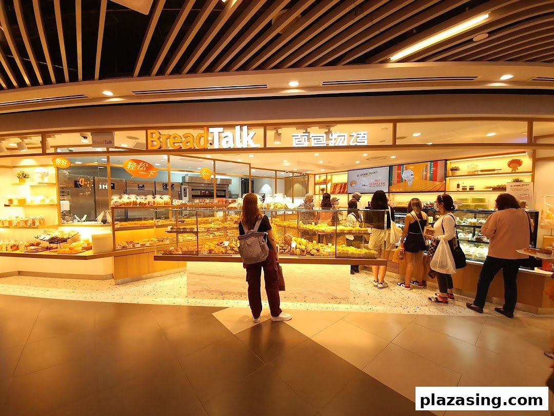 Customers browse a brightly lit BreadTalk bakery filled with fresh pastries and bread.