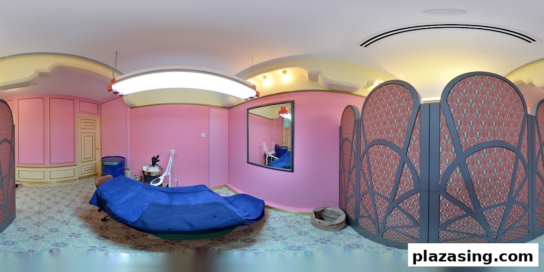 A vibrant pink and gold treatment room with a blue bed and decorative screens at Browhaus.