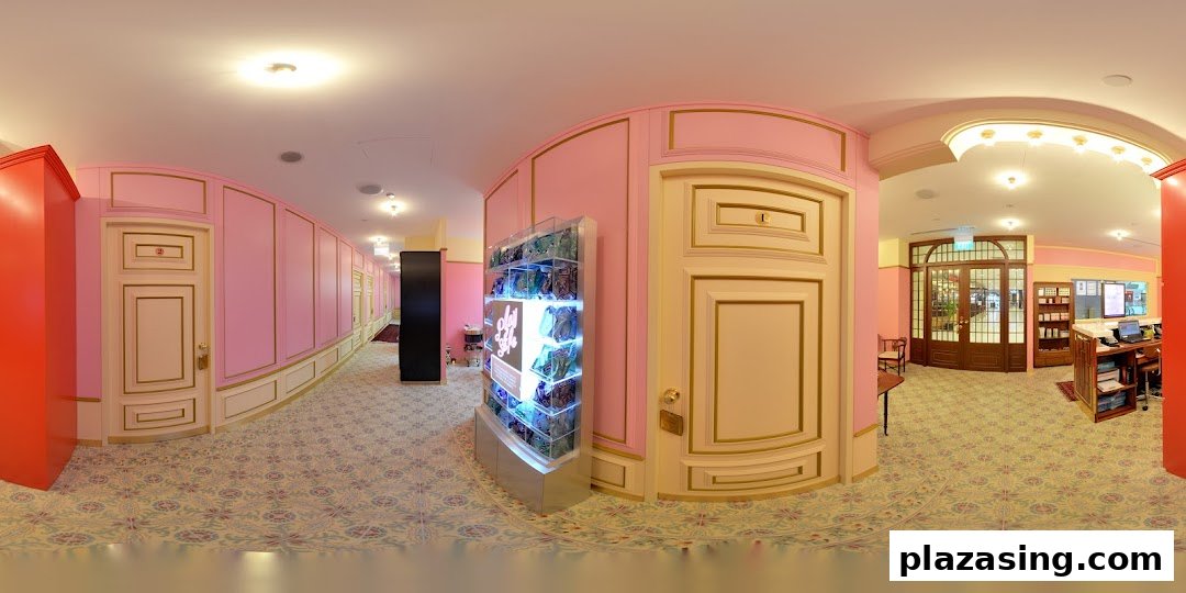 A chic pink and gold interior hallway with treatment room doors, a product display, and a reception area.