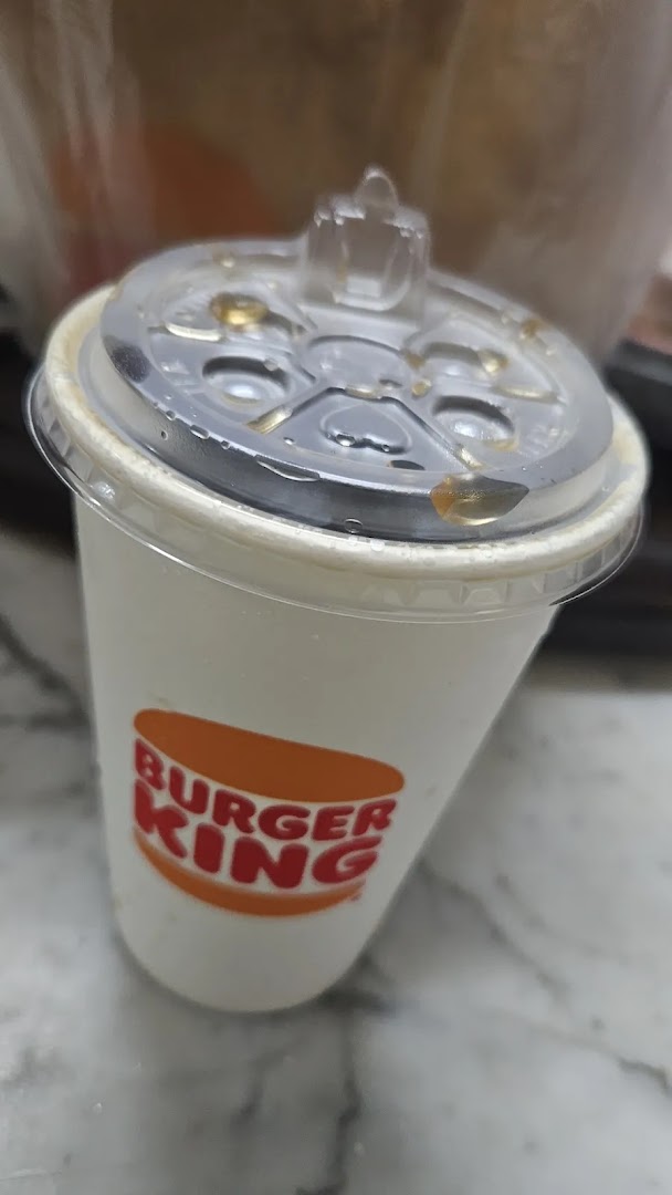 A Burger King branded drink cup with a clear lid, showing condensation.