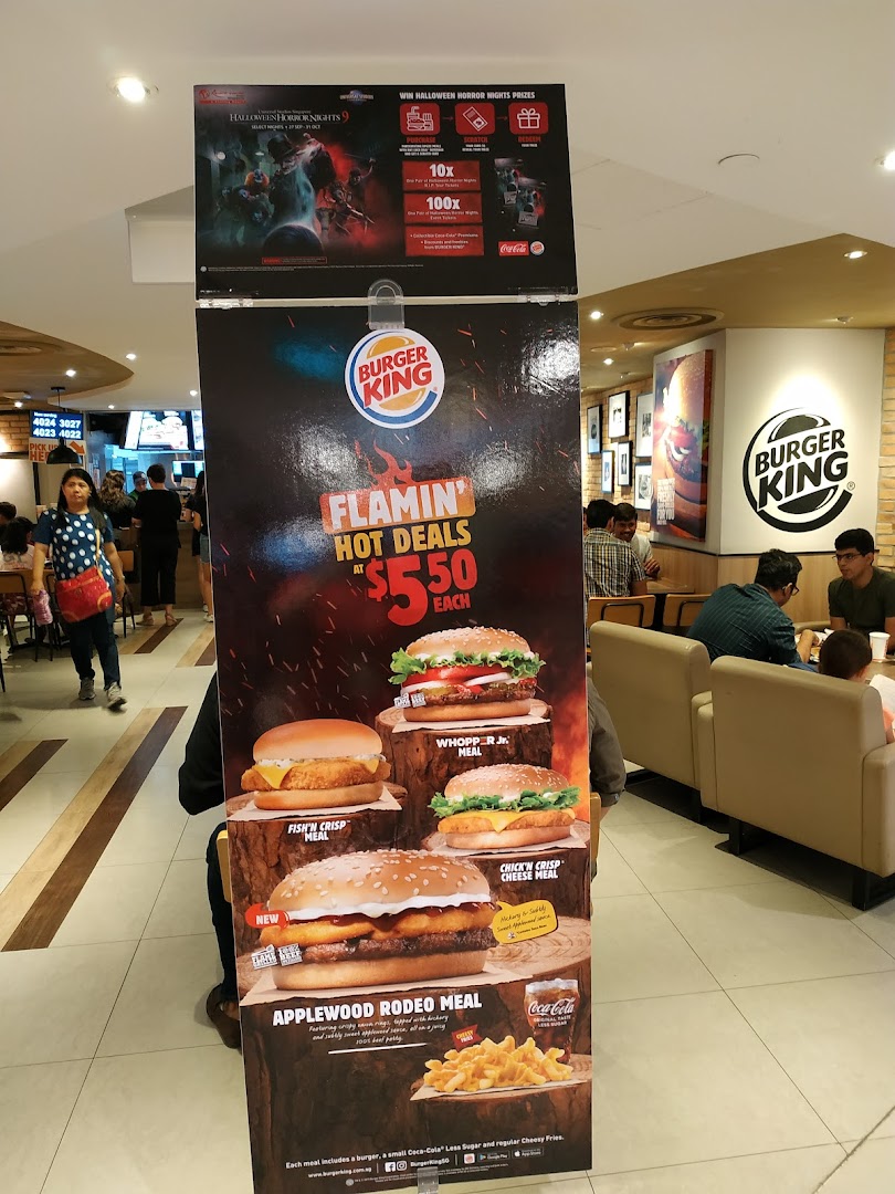 A promotional stand inside Burger King Plaza Singapura showcasing 'Flamin' Hot Deals' and Halloween prizes.