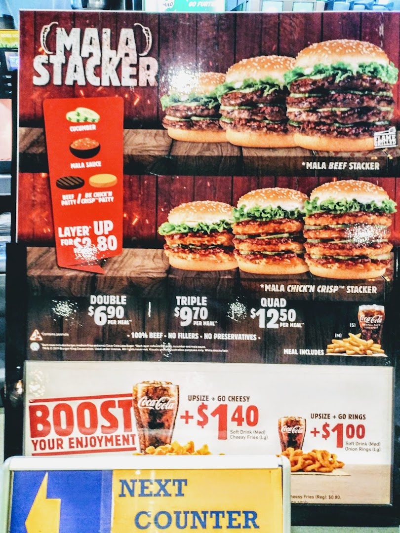 A Burger King menu board featuring Mala Stacker burgers and upsize options.