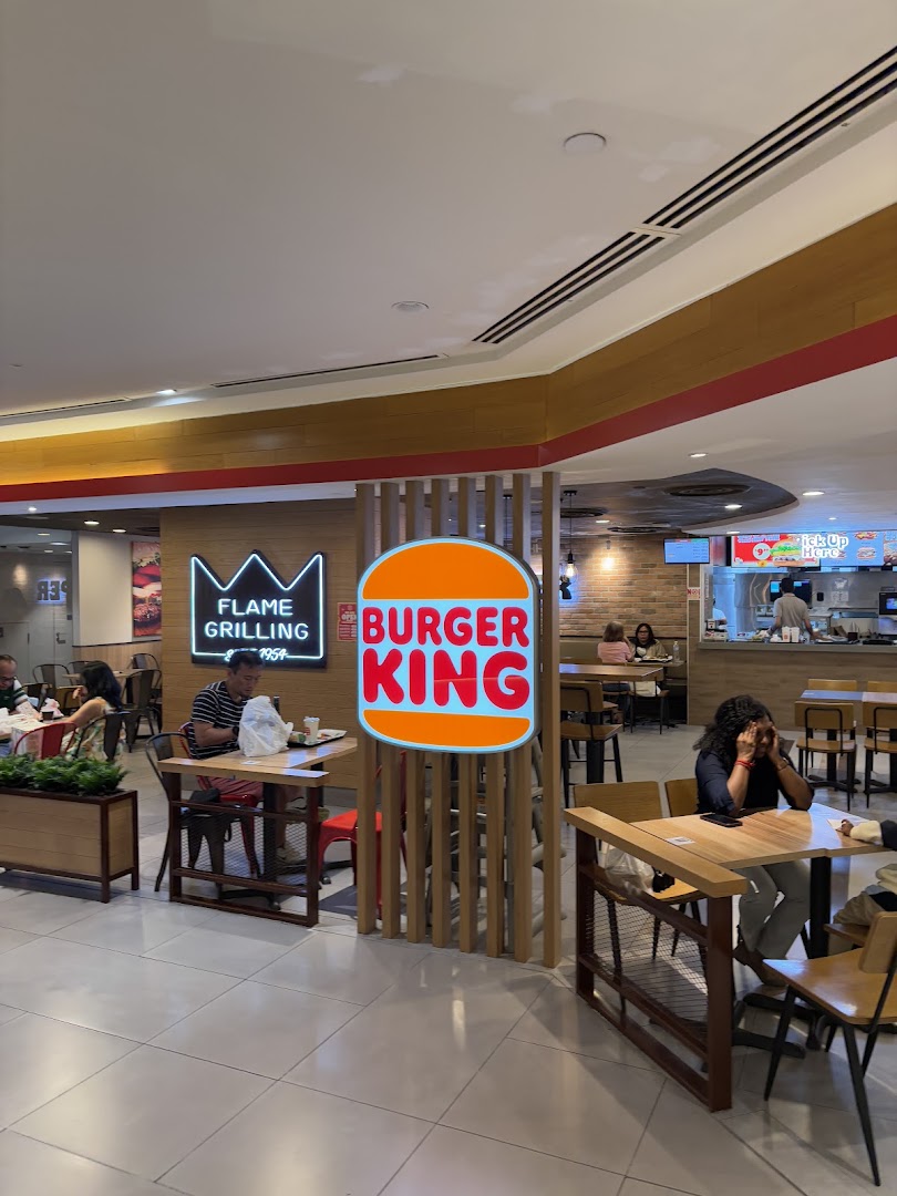 Diners enjoy meals in the spacious Burger King restaurant with prominent branding and seating.