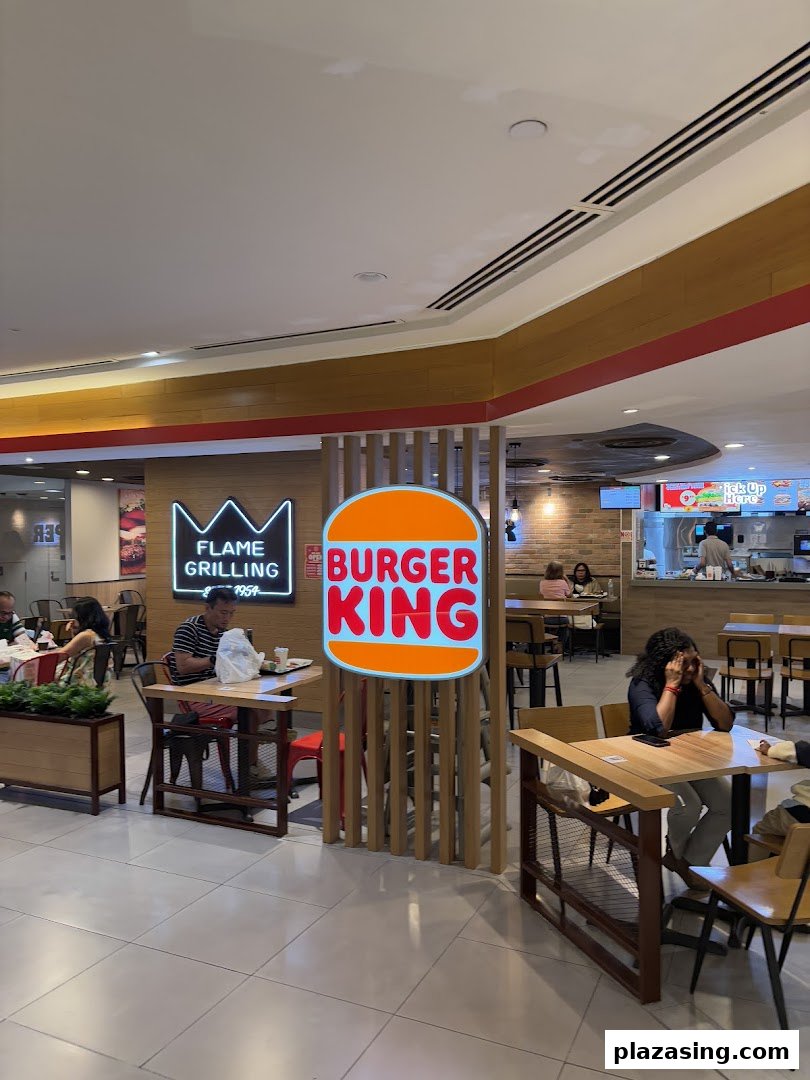 Diners enjoy meals in the spacious Burger King restaurant with prominent branding and seating.