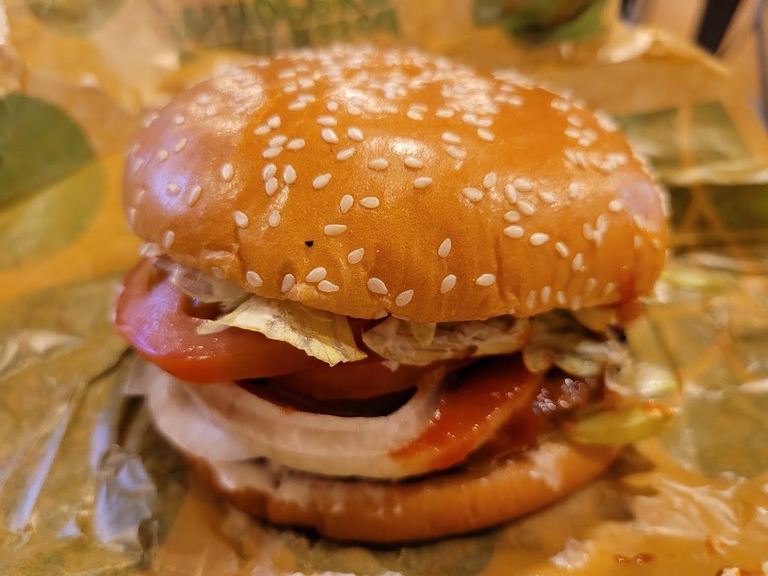 A close-up of a delicious Burger King burger with fresh ingredients on a sesame seed bun.
