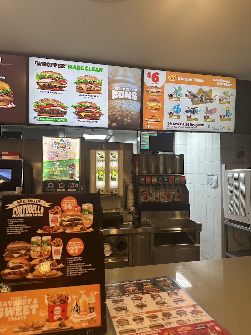Interior view of Burger King with digital menu boards and counter displays showcasing burgers and combos.
