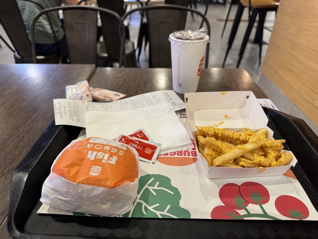 A Burger King meal with a wrapped burger, cheese fries, and a drink on a tray.