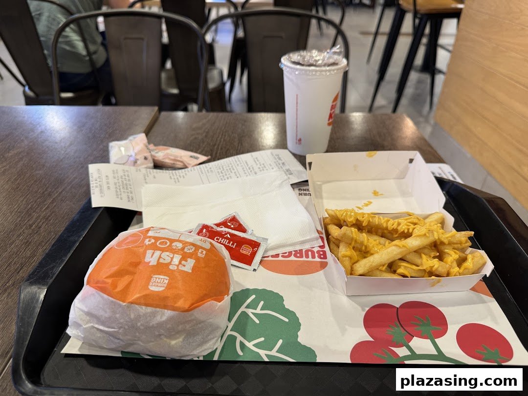 A Burger King meal with a wrapped burger, cheese fries, and a drink on a tray.