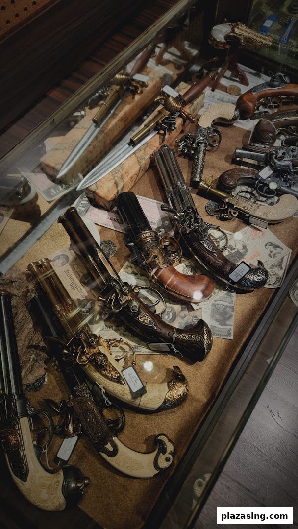 A close-up view of a display case showcasing ornate antique-style pistols, daggers, and historical artifacts.