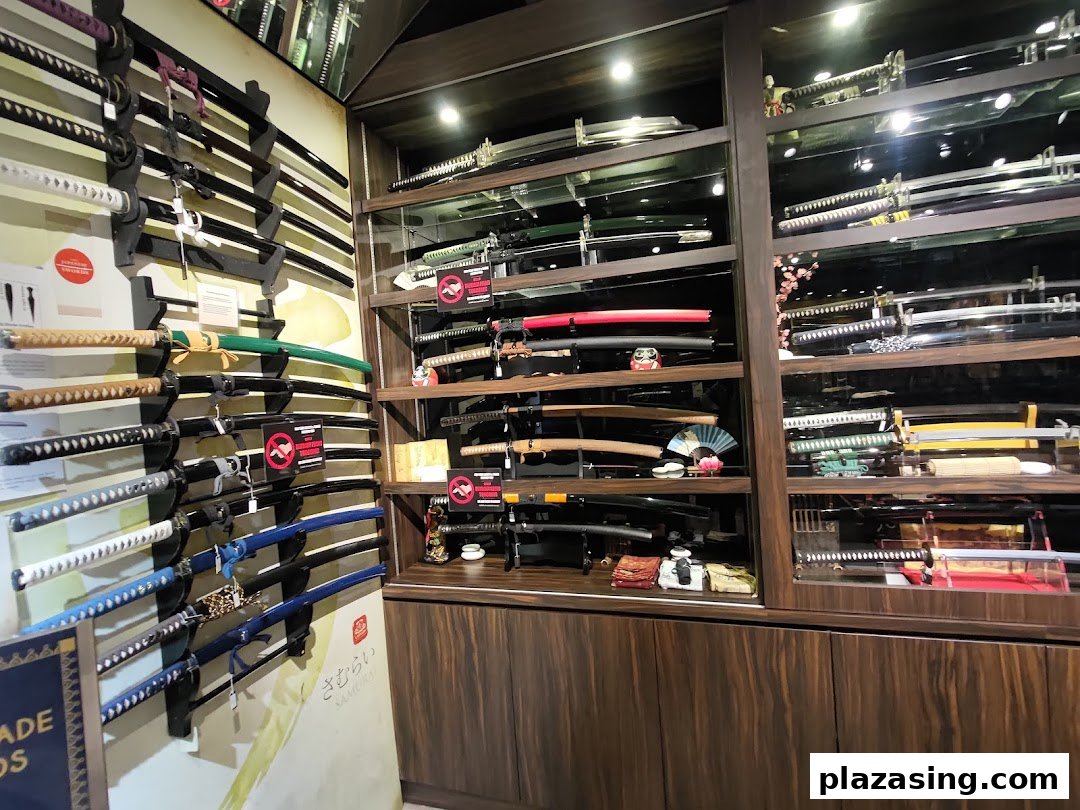 A shop interior showcasing a diverse collection of swords, including katanas, displayed on walls and in glass cases.