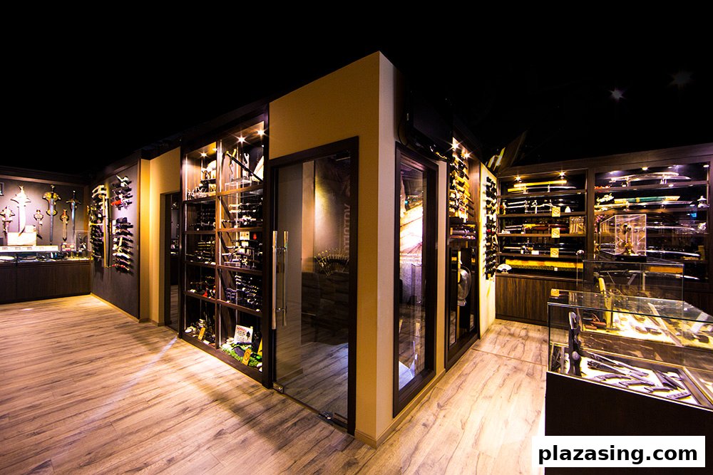 An interior view of CAESARS Swords.Guns.Armour, showcasing a wide array of swords, knives, and collectibles in display cases.