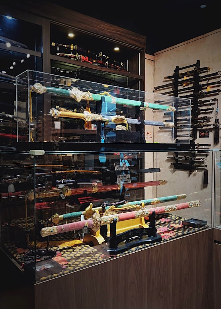 An interior view of 'CAESARS Swords.Guns.Armour' showcasing various decorative swords and blades in display cases.