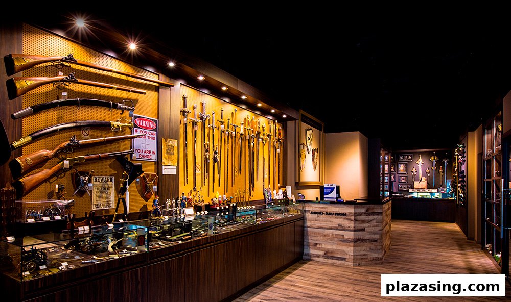 Interior view of a shop displaying an extensive collection of historical swords, firearms, and armour.