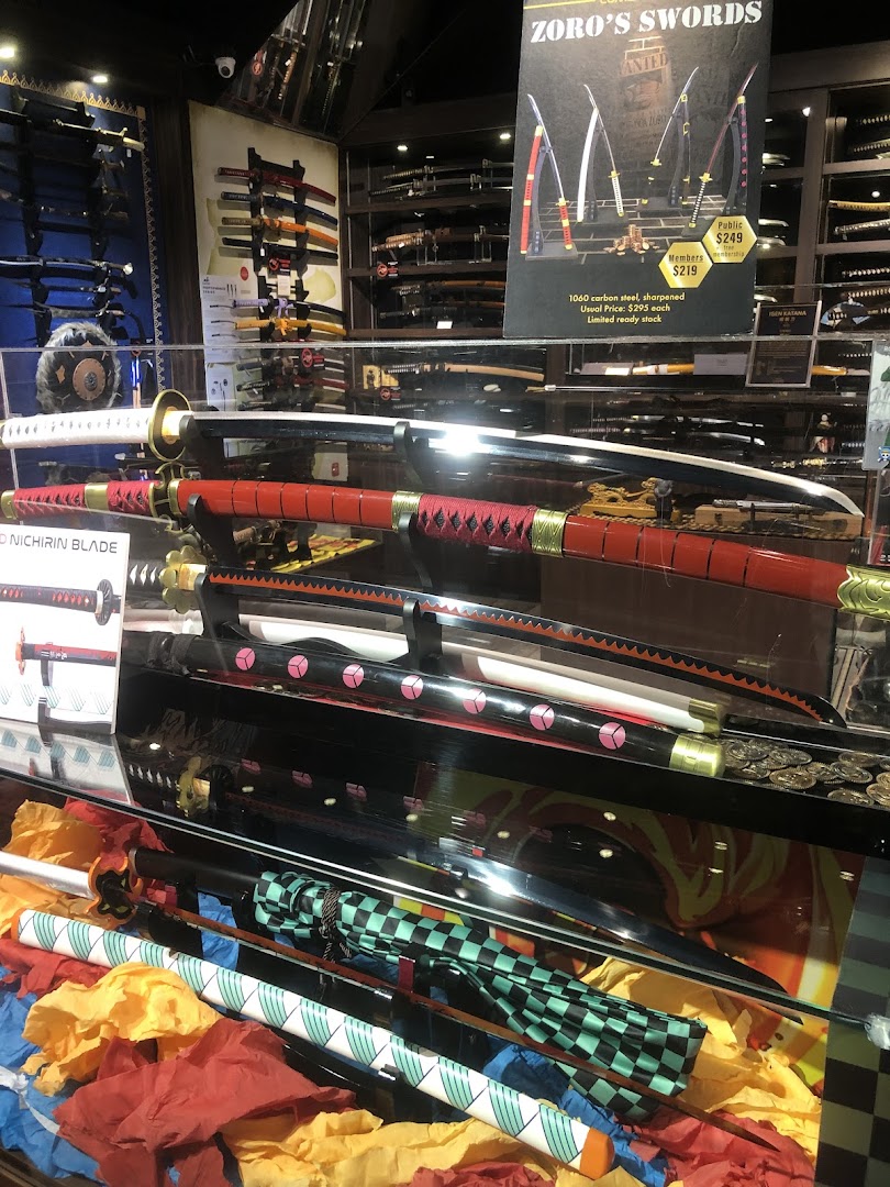 An interior shot of a shop displaying various swords, katanas, and themed merchandise in a glass case.
