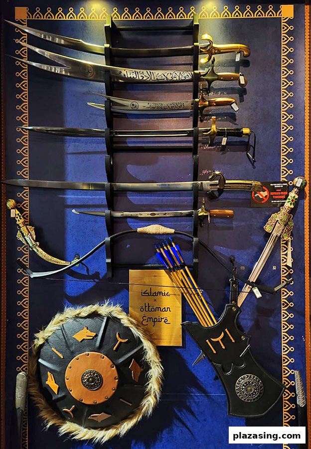 A display of historical swords, a bow and arrows, and a shield, showcasing Ottoman Empire themed weaponry.