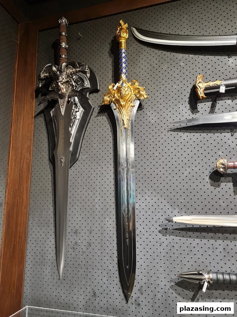 A display of ornate, fantasy-style swords and bladed weapons on a dark pegboard wall.