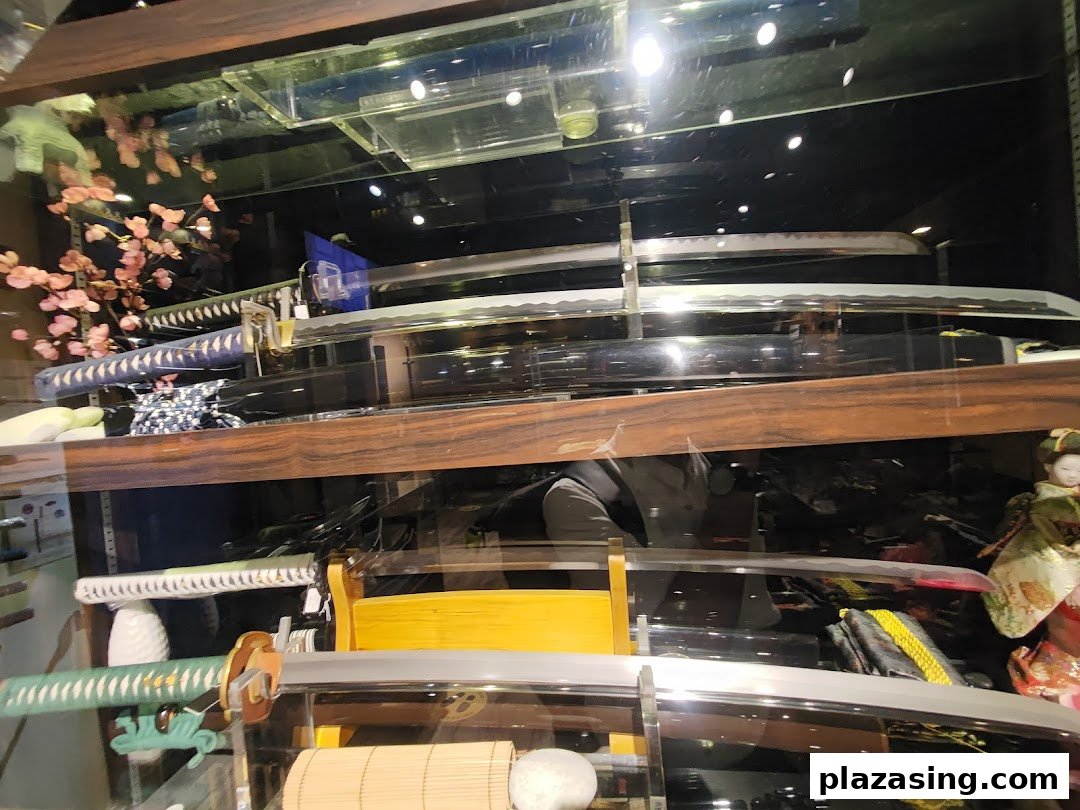 A display case showcasing an array of intricately designed swords, including katanas, with traditional Japanese decor.