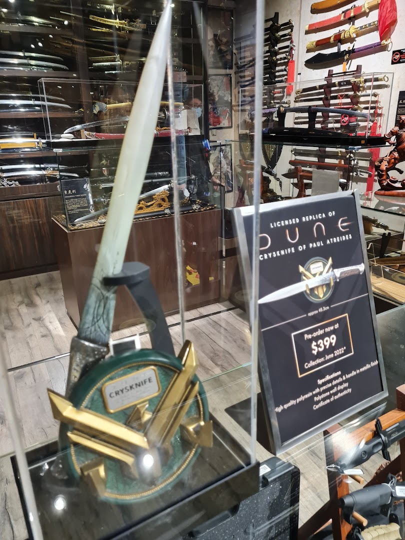 Interior view of a shop displaying swords and a licensed Dune Crysknife replica.
