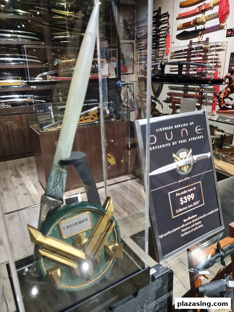 Interior view of a shop displaying swords and a licensed Dune Crysknife replica.