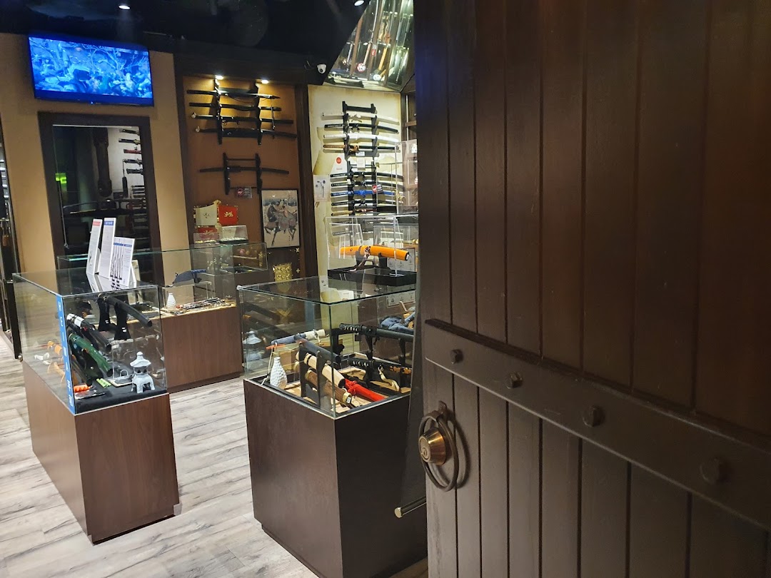 Interior view of CAESARS Swords.Guns.Armour shop, showcasing display cases with replica weapons and wall-mounted swords.