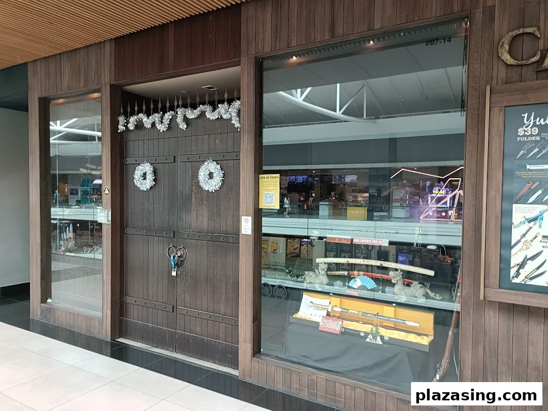 The shopfront of CAESARS Swords.Guns.Armour, featuring a display window with swords and a festive entrance.