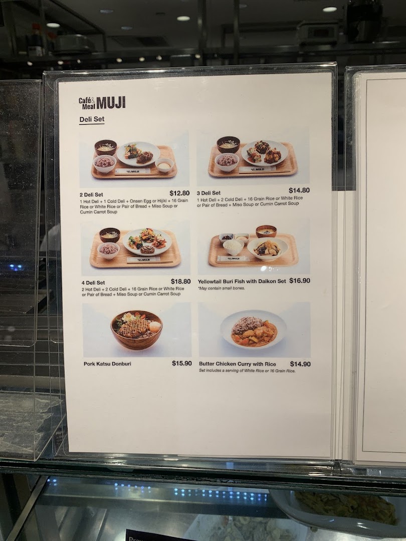 A close-up view of the menu board for Café & Meal MUJI, displaying various deli sets and main dishes.