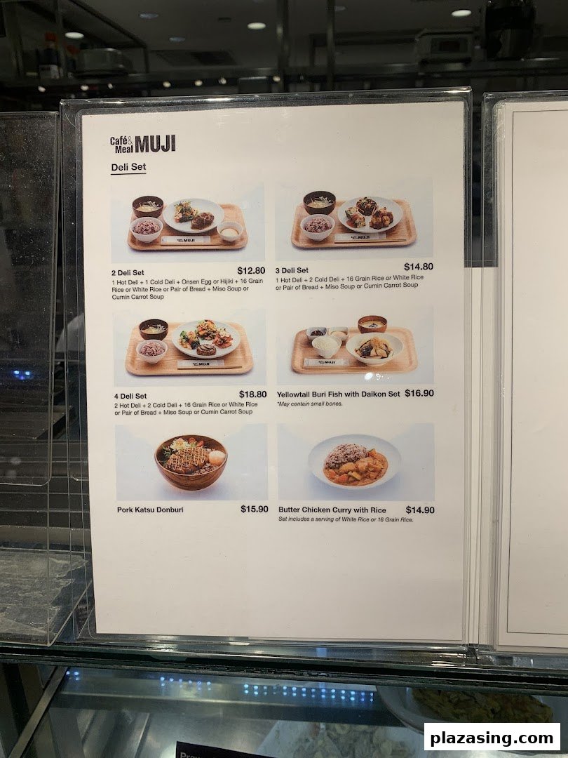 A close-up view of the menu board for Café & Meal MUJI, displaying various deli sets and main dishes.