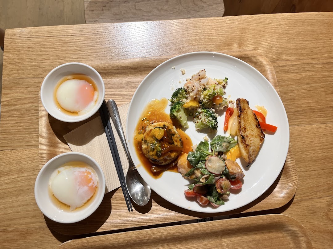 A healthy and wholesome meal featuring fish, vegetables, and soft-boiled eggs on a wooden tray.