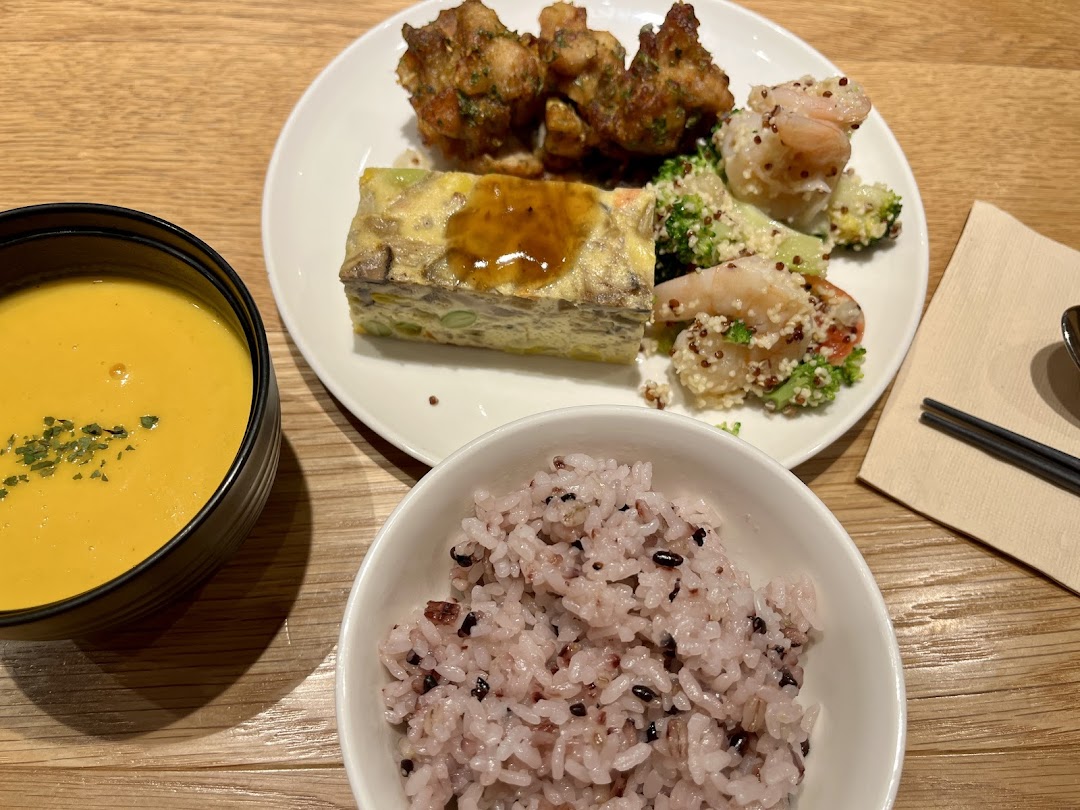 A balanced meal set featuring a vibrant soup, mixed grain rice, and a main plate with various dishes.