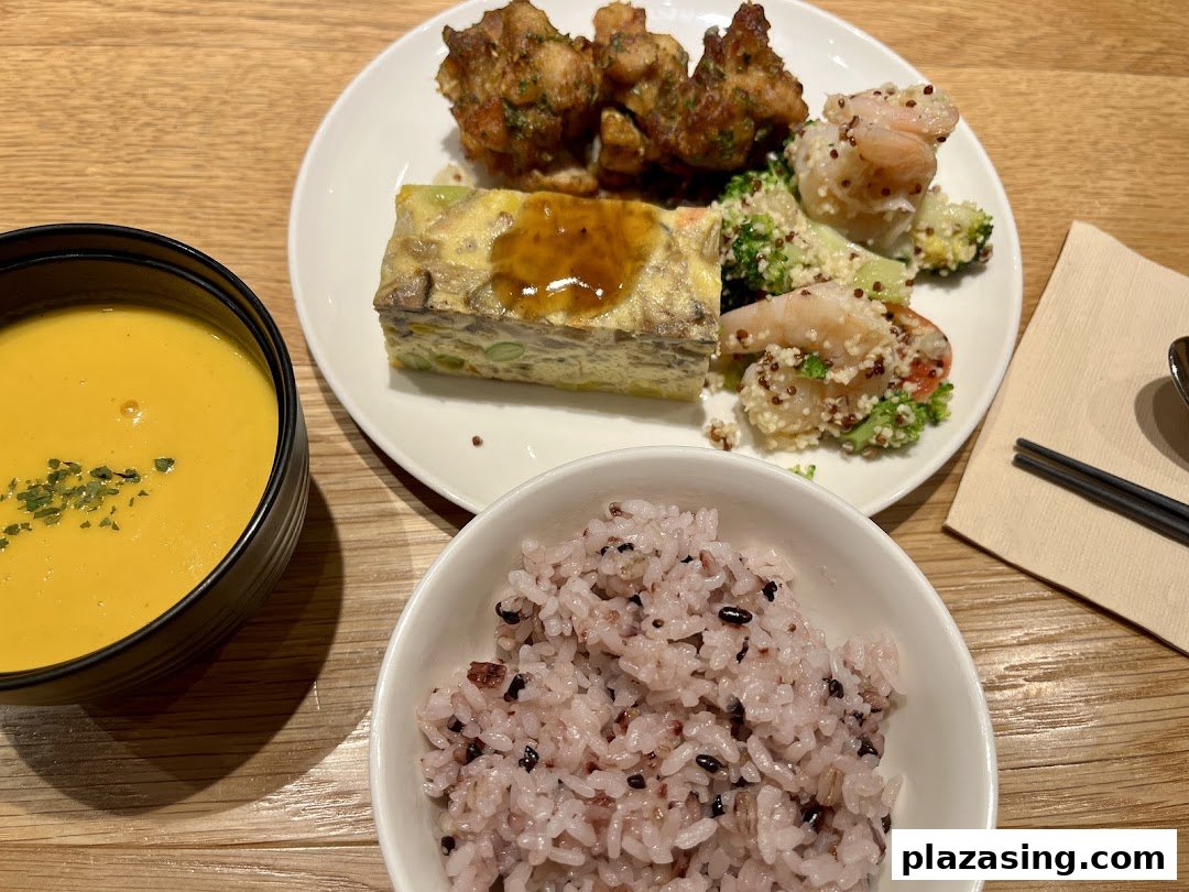 A balanced meal set featuring a vibrant soup, mixed grain rice, and a main plate with various dishes.