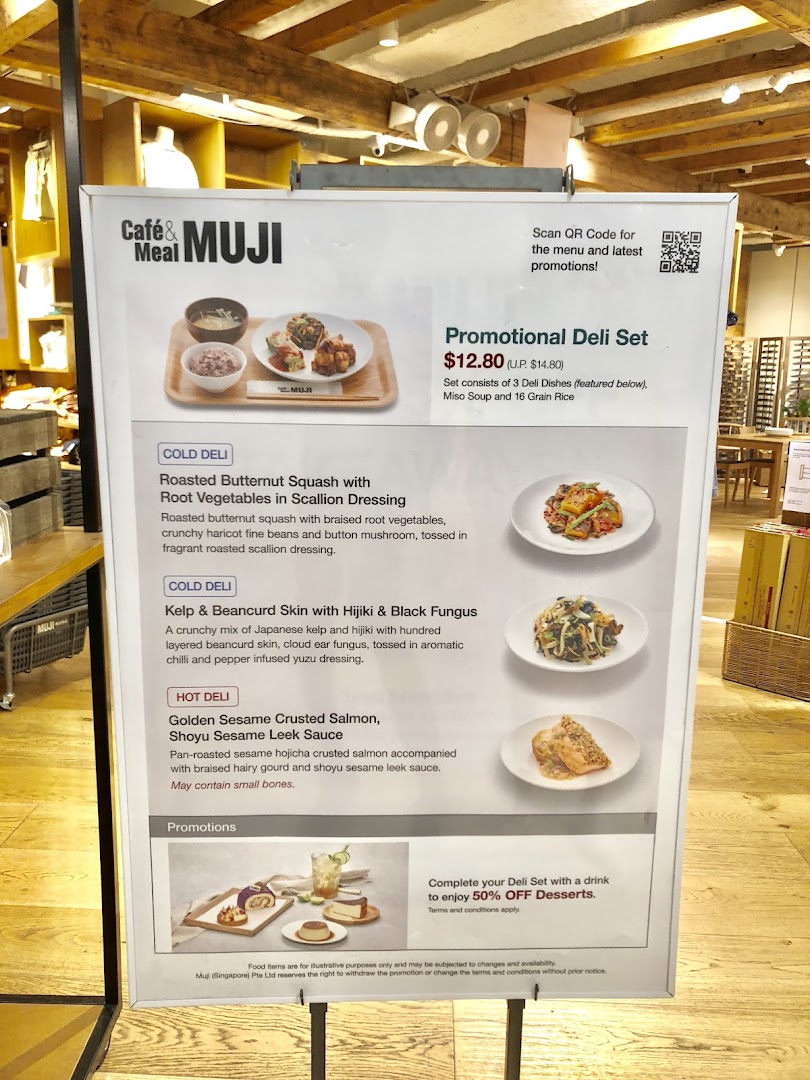 A promotional menu board for Café & Meal MUJI, featuring a deli set and individual dish descriptions.