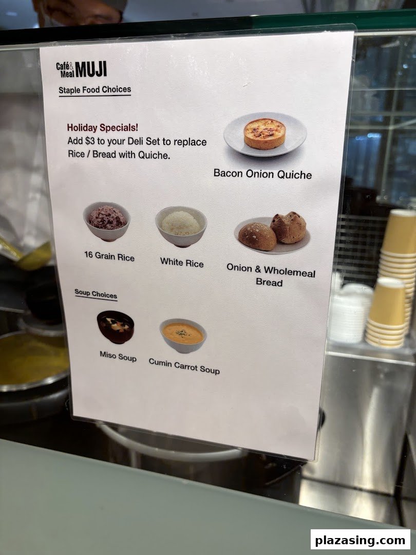 A menu display at CafèMeal MUJI showcasing staple food choices, soups, and a quiche special.