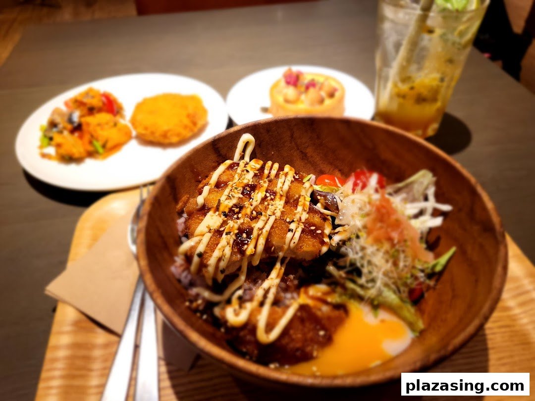 A delicious meal featuring a rice bowl, side dish, dessert, and a refreshing drink at CafèMeal.