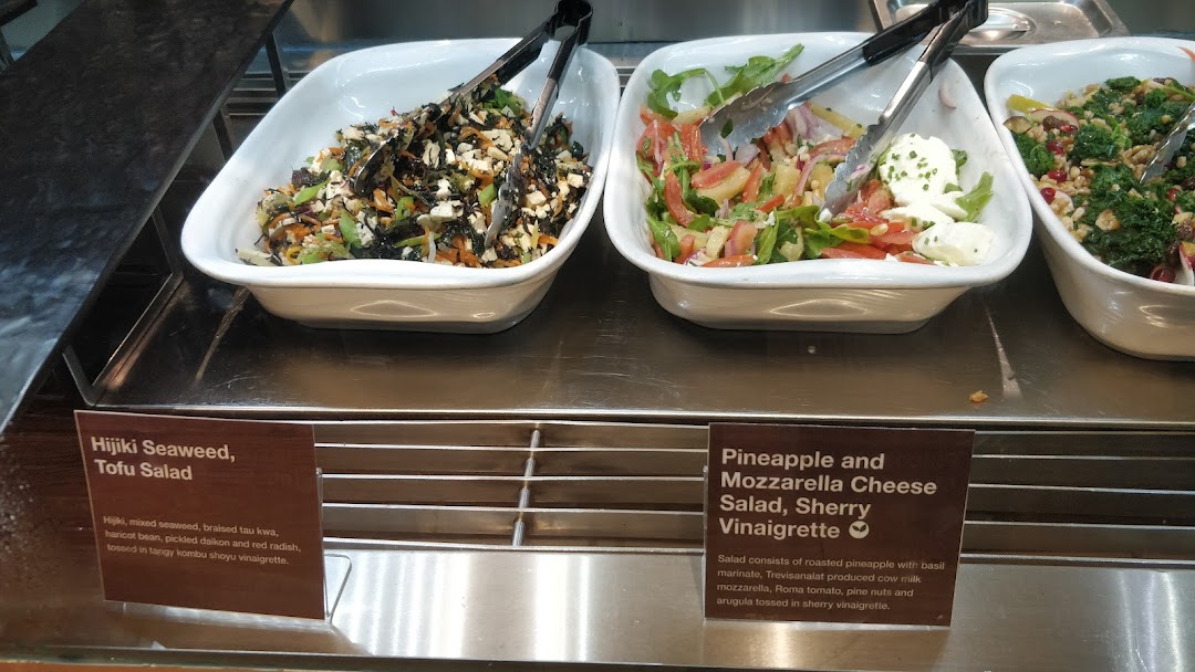 Close-up of fresh salads, including Hijiki Seaweed Tofu Salad and Pineapple Mozzarella Cheese Salad, displayed in white bowls.