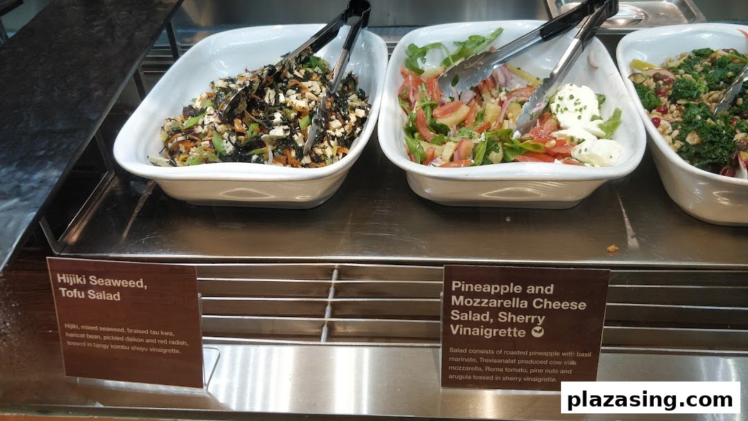 Close-up of fresh salads, including Hijiki Seaweed Tofu Salad and Pineapple Mozzarella Cheese Salad, displayed in white bowls.