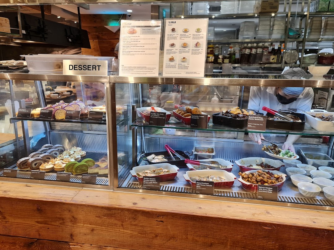 A vibrant display of freshly prepared desserts and hot dishes at CafèMeal MUJI's food counter.