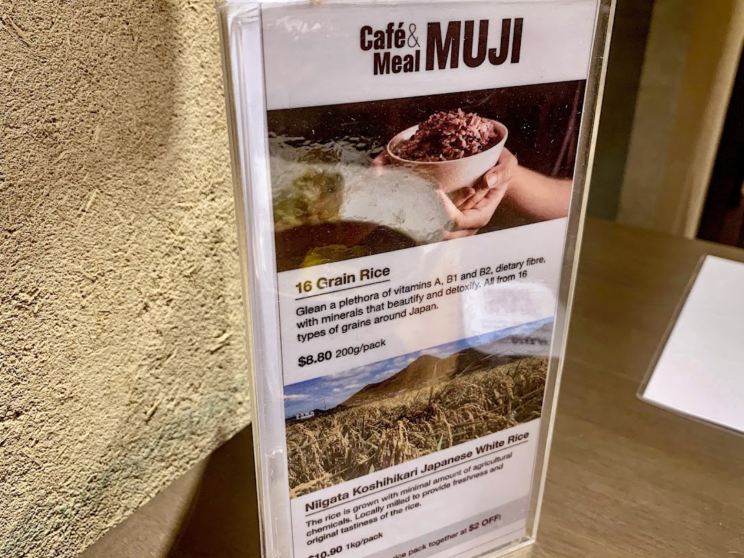 A close-up of a menu display featuring healthy rice options and their descriptions at Café&Meal MUJI.