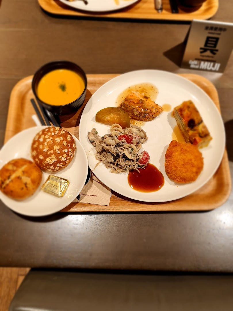 A beautifully presented meal on a wooden tray, featuring soup, bread, and various delectable dishes.