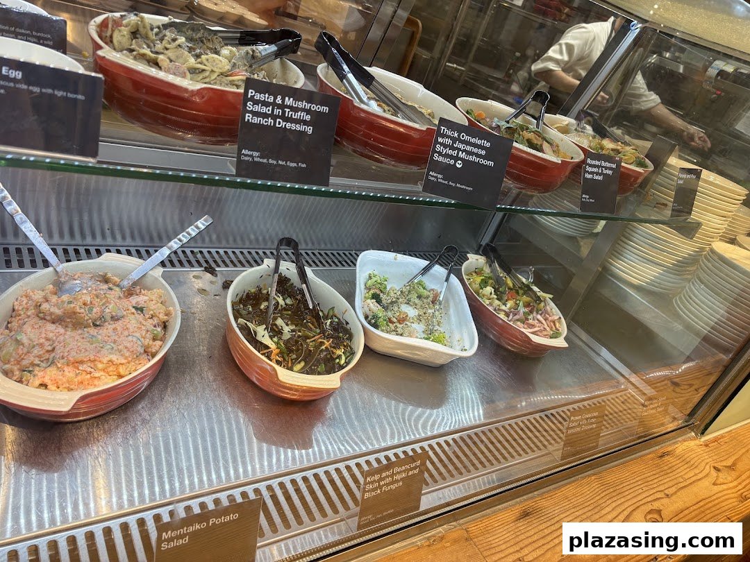 A vibrant display of fresh salads and prepared dishes in a refrigerated counter at CafèMeal.