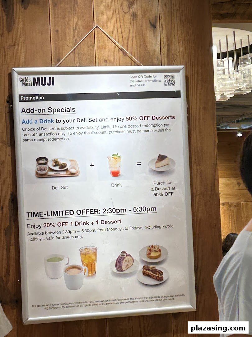 A promotional sign for CafèMeal MUJI displaying special offers on deli sets, drinks, and desserts.