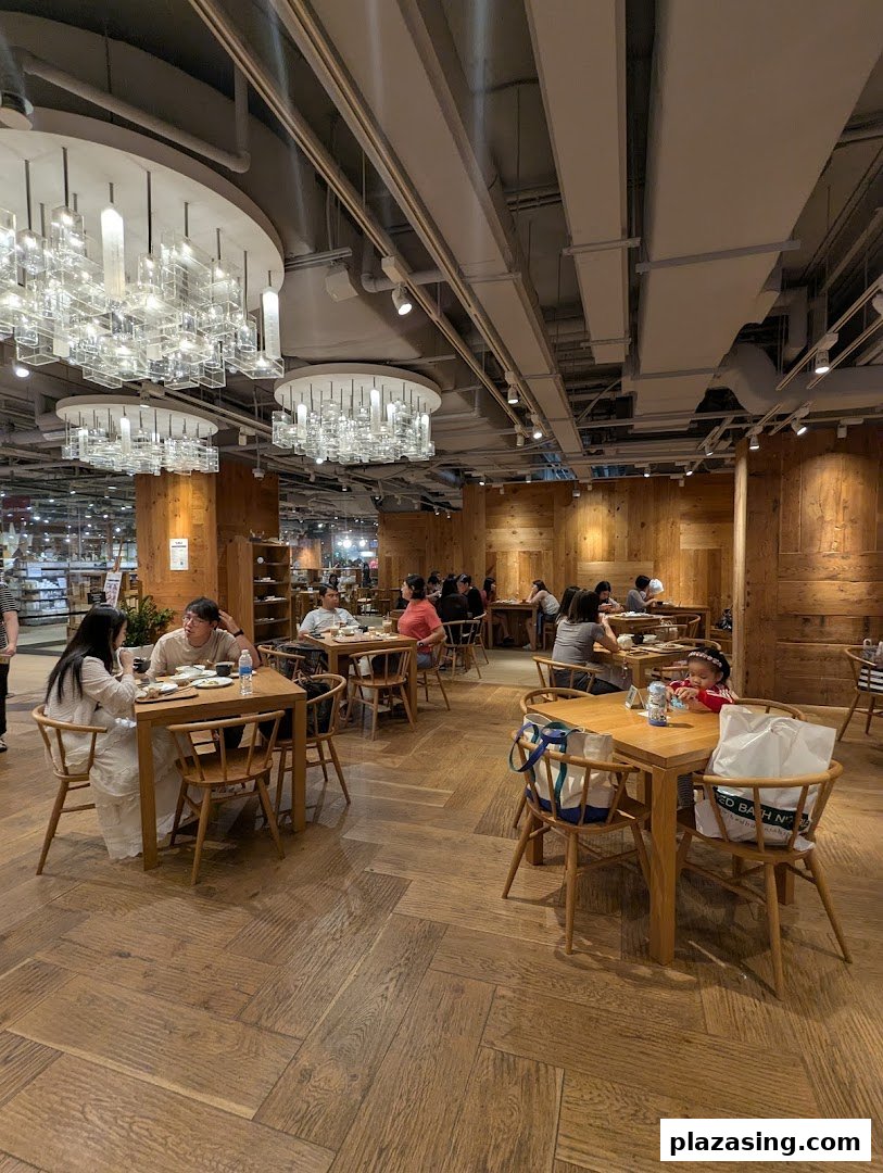 Customers dine in a spacious, wood-themed cafe with modern chandeliers and minimalist decor.