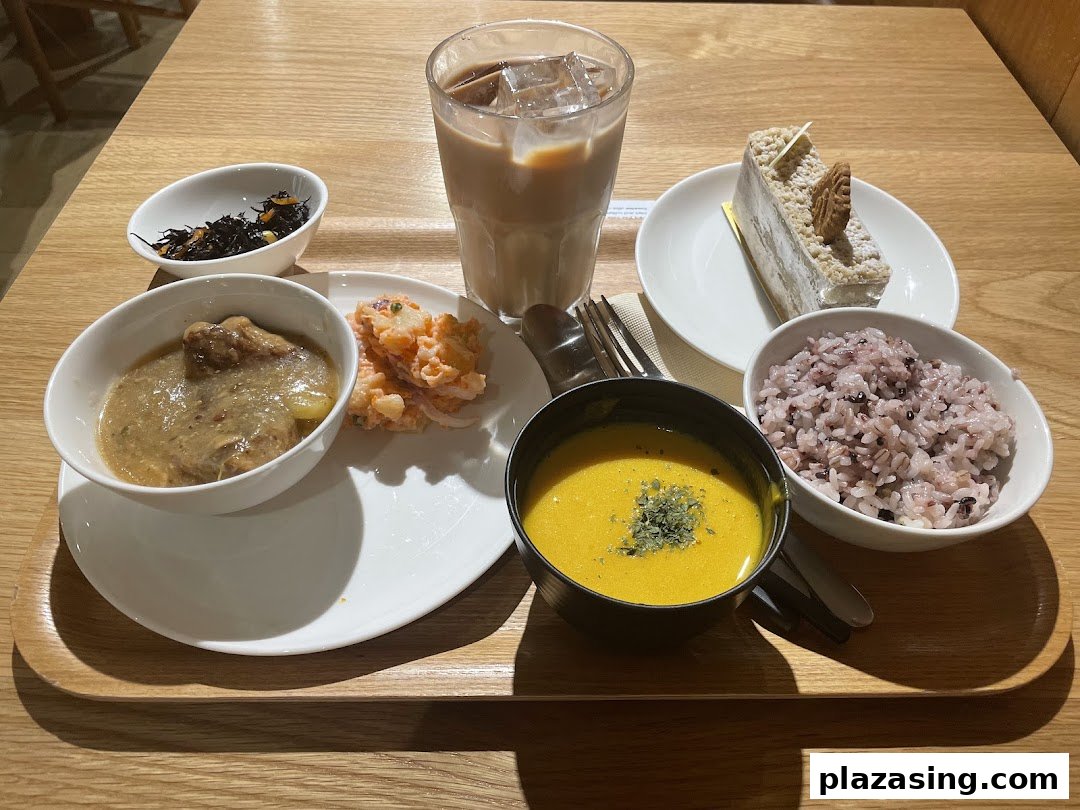 A delicious meal set with multiple dishes, a drink, and dessert on a wooden tray.