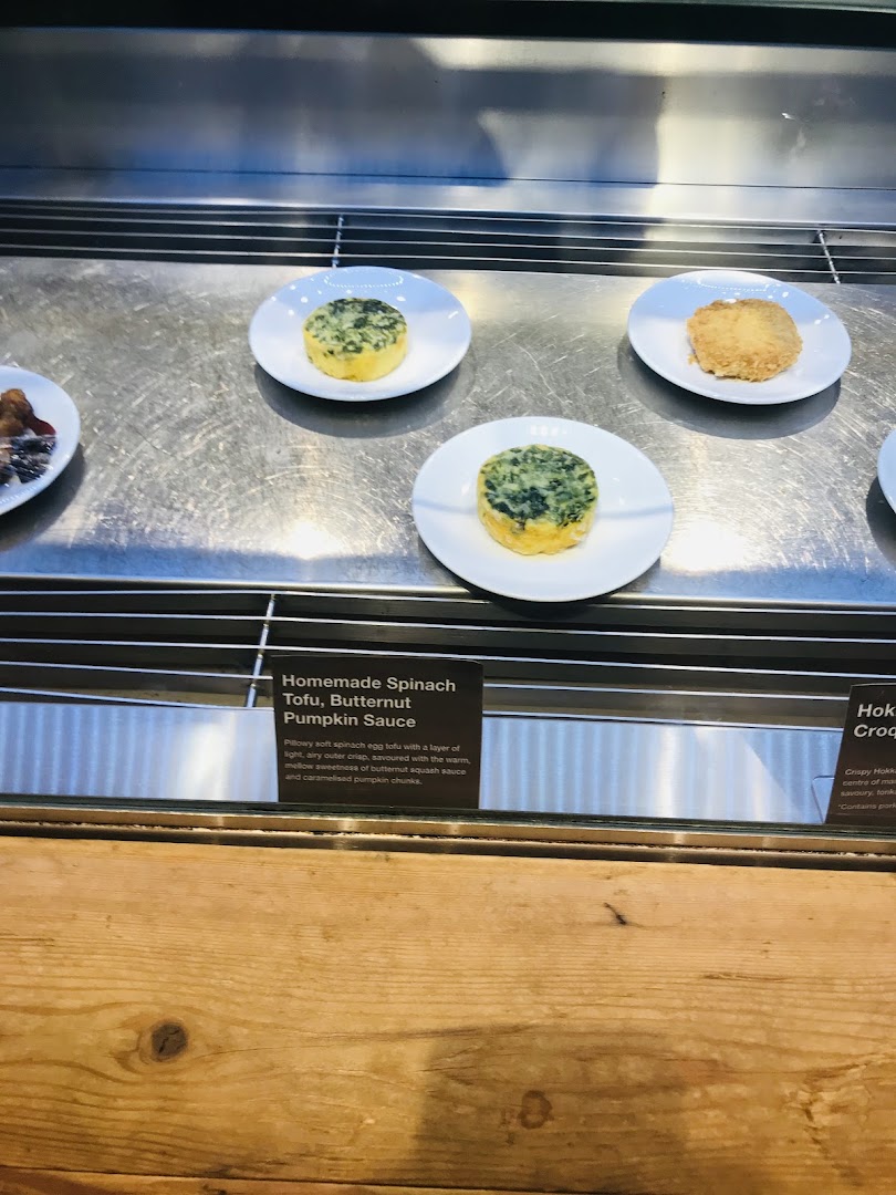 Delicious spinach tofu and other dishes displayed in a modern food counter at CafèMeal.