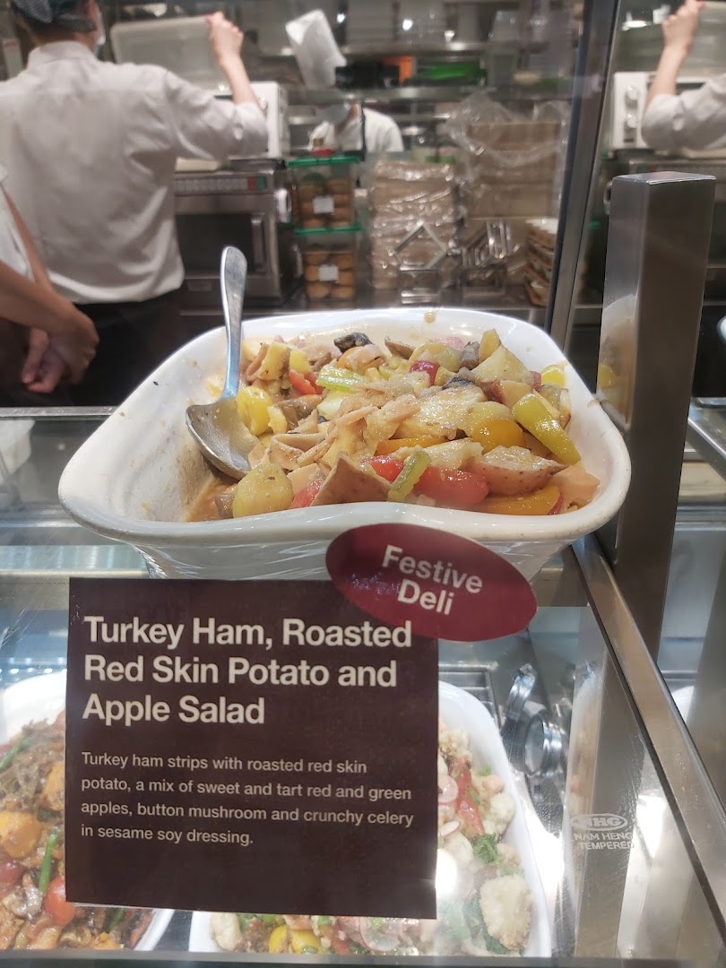 A vibrant turkey ham, potato, and apple salad displayed in a deli counter at CafèMeal.