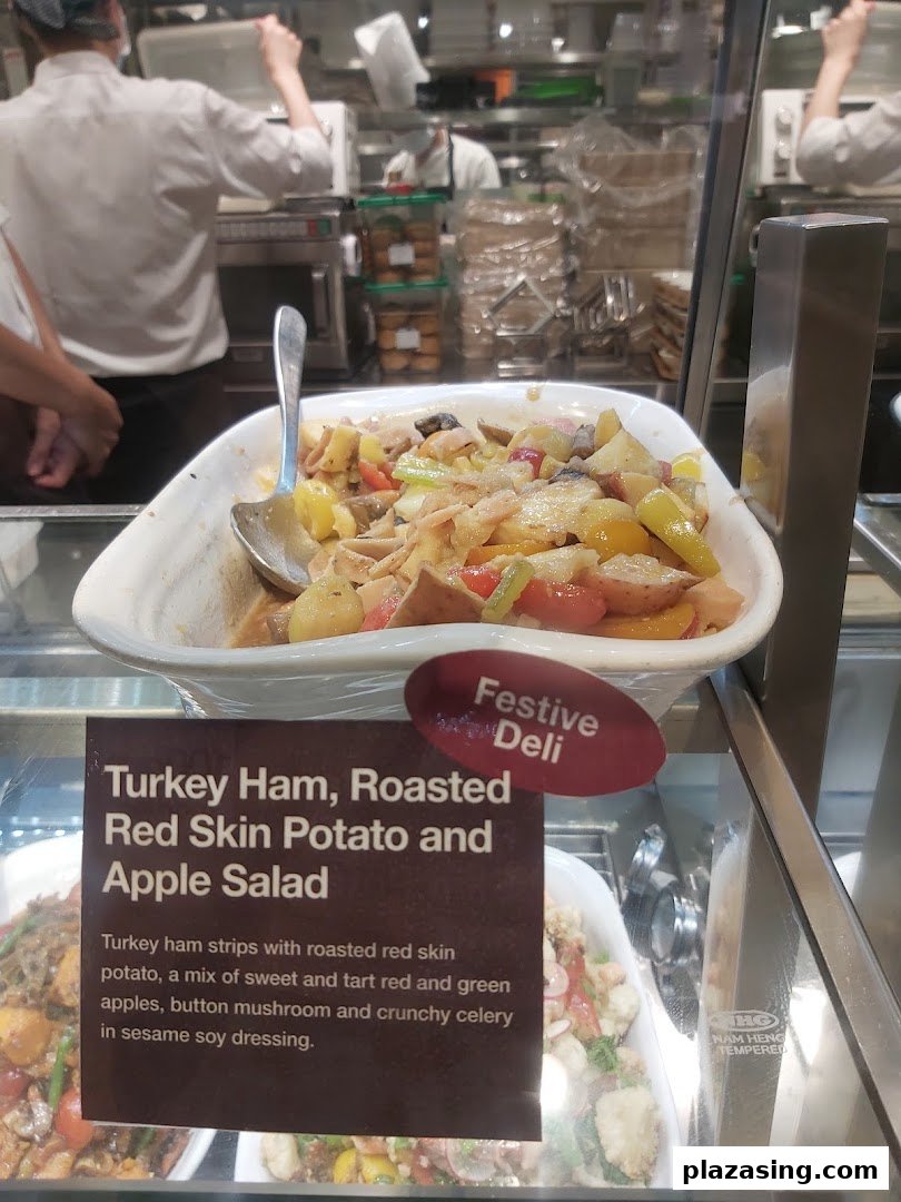 A vibrant turkey ham, potato, and apple salad displayed in a deli counter at CafèMeal.