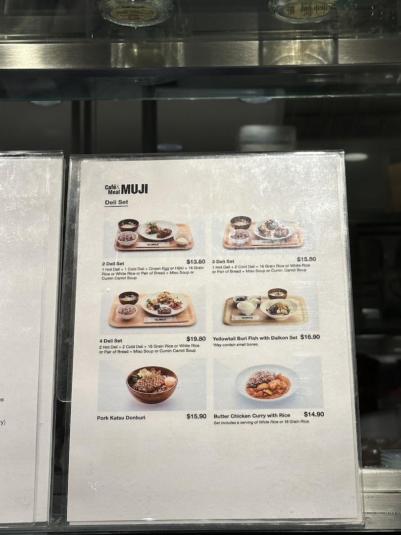 A close-up of the menu board at CafèMeal MUJI, showcasing various deli sets and main dishes.