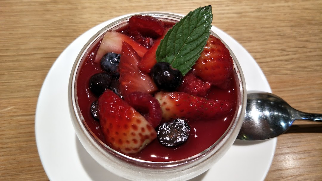 A vibrant berry dessert with strawberries, blueberries, and mint in a glass.