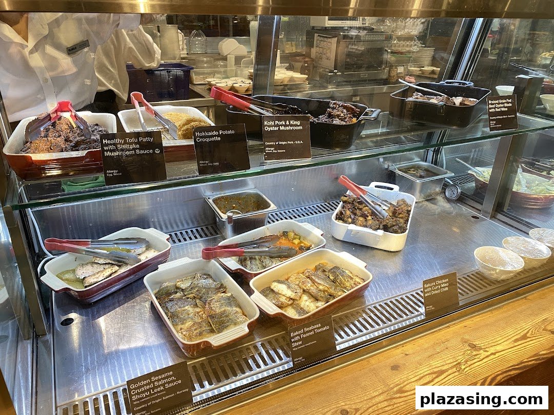 A vibrant display of freshly prepared hot dishes, including healthy options and Japanese-inspired cuisine, at CafèMeal.
