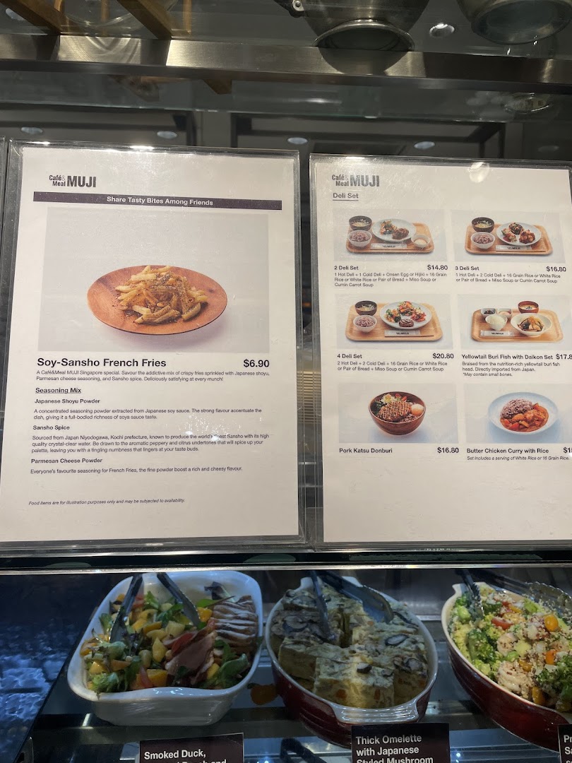Close-up view of Café&Meal MUJI's menu boards displaying various Japanese-inspired dishes and deli sets.